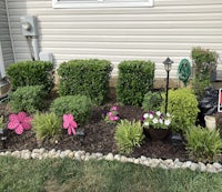 a flower bed in front of a house