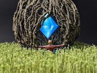 a man is standing in the middle of a grassy field with a blue diamond