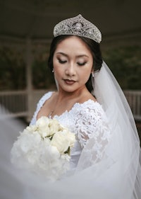 a bride wearing a tiara and holding a bouquet