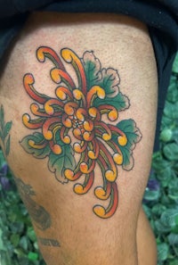 a tattoo of a flower on a man's thigh