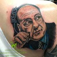a tattoo of a man with a cigar on his shoulder