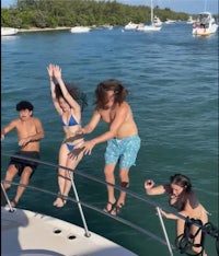 a group of people jumping off a boat