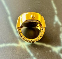 a gold ring sitting on top of a marble table