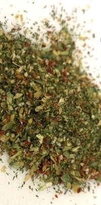 a pile of herbs and spices on a white surface