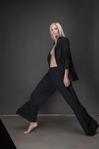a woman in a black blazer and wide leg pants