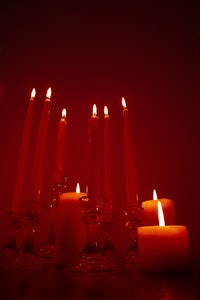 a group of candles in front of a red background