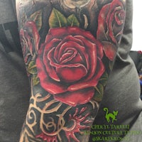 a tattoo of red roses on a sleeve