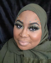 a woman wearing a hijab and green makeup