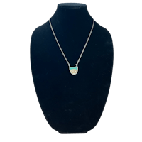 a silver and turquoise necklace on a mannequin