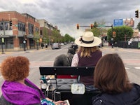 a group of people riding in a horse drawn carriage on a city street