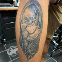 a tattoo of a skeleton with a rosary on it
