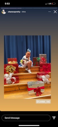 a girl is sitting on a set of stairs with gifts