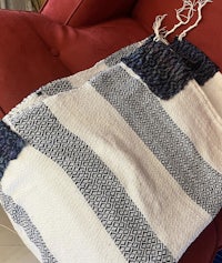 a blue and white striped towel on a red couch