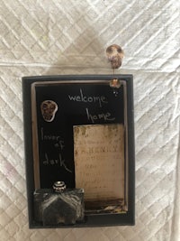 a black frame with a skull and a piece of paper in it