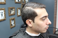 a man sitting in a barber shop with his hair cut