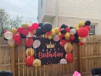 a birthday party with balloons and decorations on a fence