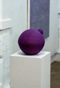 a purple ball on a pedestal in a room