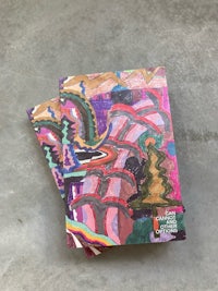 a set of colorful notebooks on a concrete surface