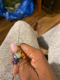 a person holding a ring with different colored stones