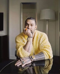 a man in a yellow sweater sitting at a table