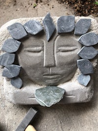 a stone sculpture with a face made out of stones