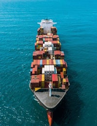 an aerial view of a container ship in the ocean