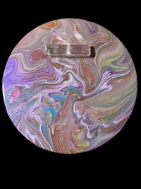 a pink and purple marbled plate on a black background
