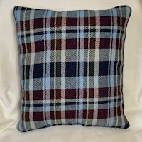 a plaid pillow with a blue, green, and brown pattern