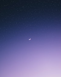 a purple sky with a crescent and stars