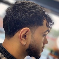 a man with a curly haircut in a barber shop