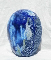 a blue and white ceramic sculpture on a white surface