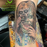 a tattoo of a woman with a zombie face on her arm