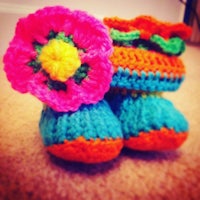 a pair of crocheted baby shoes with a flower on them