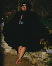 a man in a black cape is posing for a picture