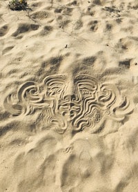 a sand drawing of a face in the sand