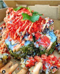 a sushi roll covered in sauce and garnishes