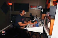 a man sitting at a desk in a recording studio