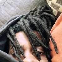 a man with dreadlocks laying on a couch