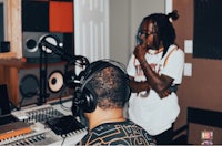 two men in a recording studio with headphones on
