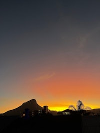 a sunset with a mountain in the background