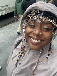 a woman wearing a beaded headband smiles for the camera